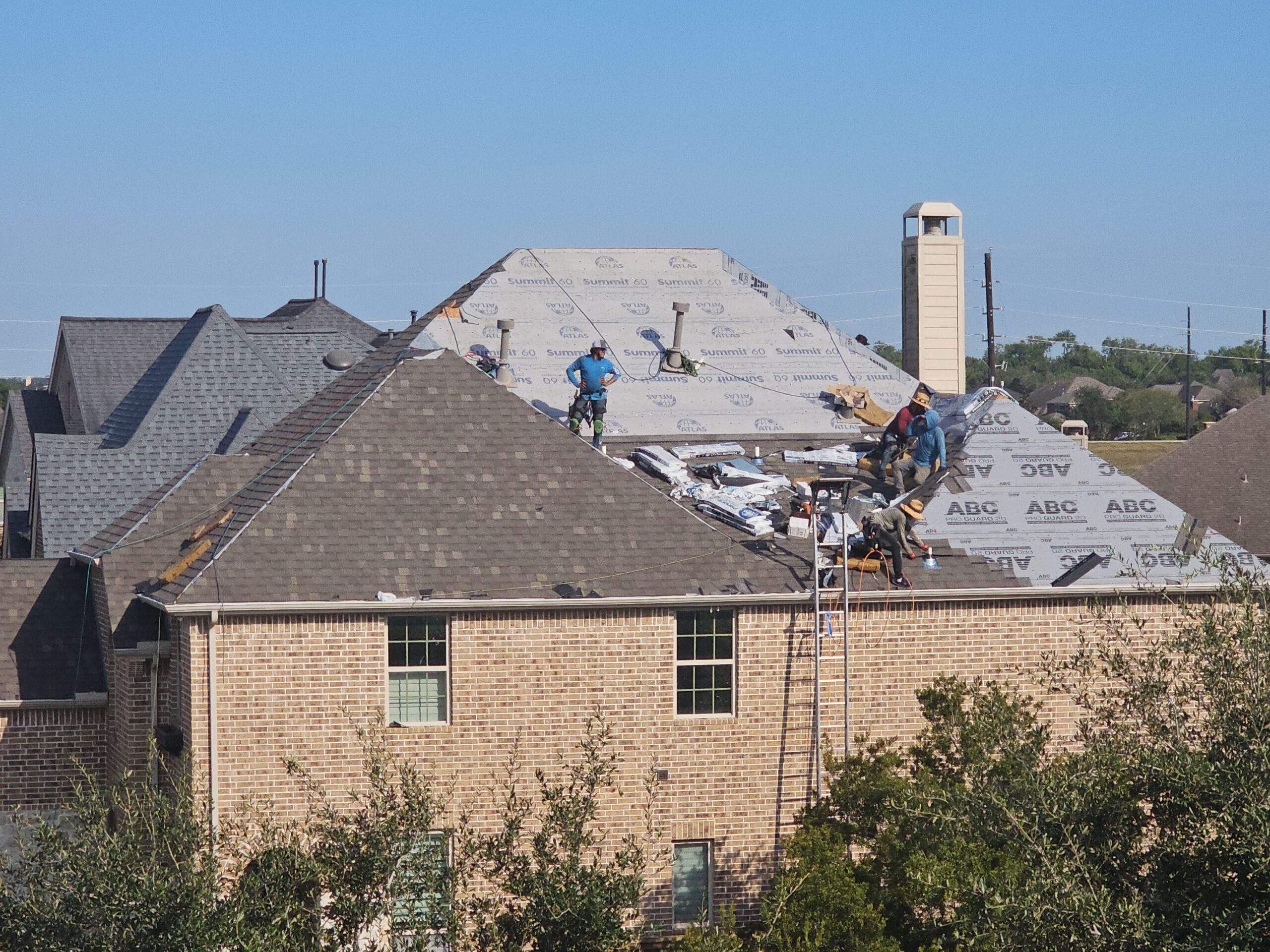 O&M Construction professional roofing crew working on multi-family roof in Houston